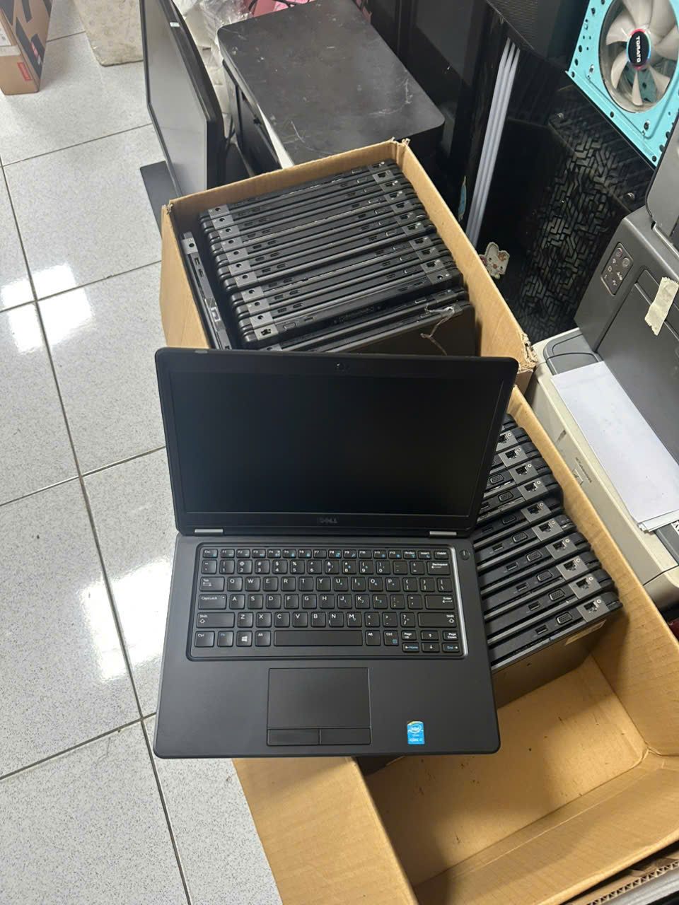 Laptop mở màn hình bên cạnh các thùng máy